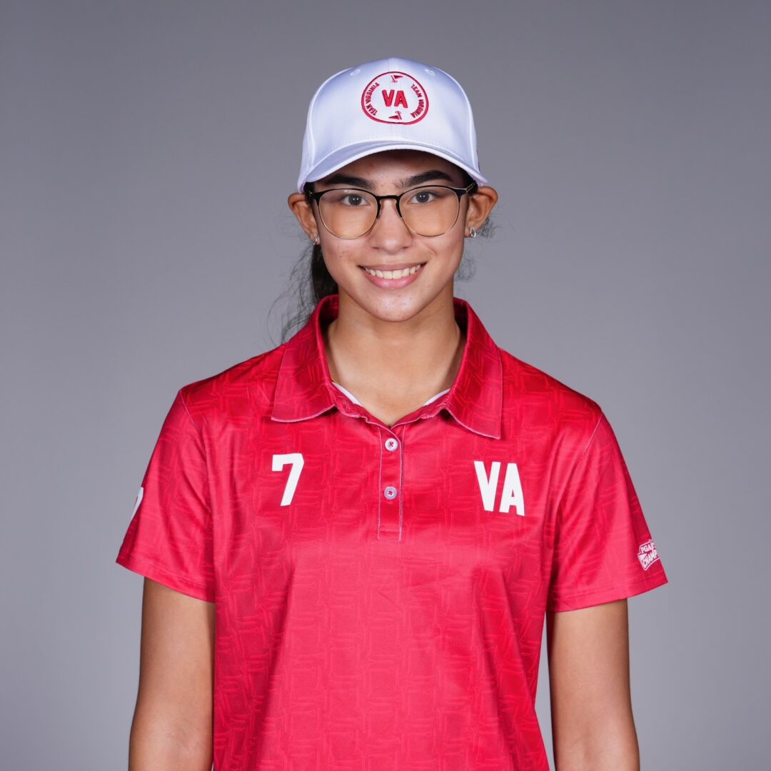 Young athlete in red sportswear and white cap smiling.